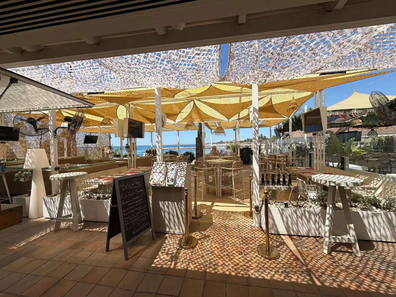 The terrace entrance with menu boards and shade sails